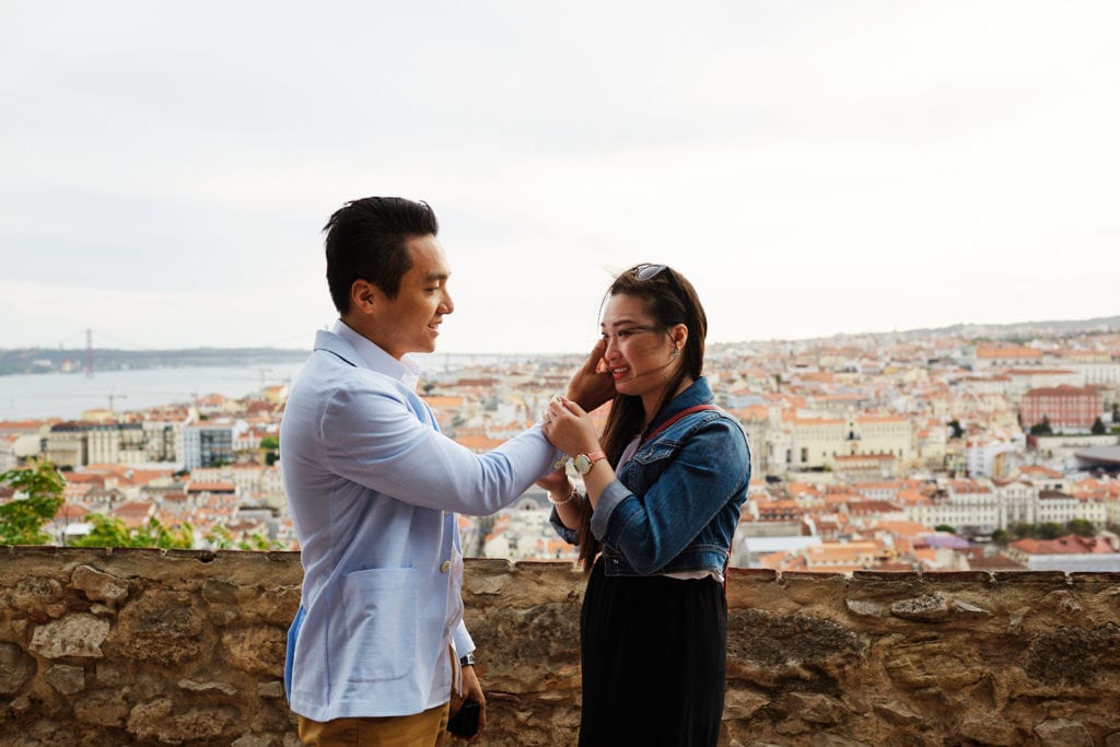 A man wipes his girlfriend's tears after he proposed in an emotional marriage proposal in Lisbon, Portugal