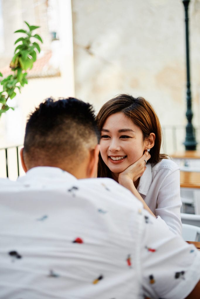 Eliza Sam sitting at a café in Lisbon with her husband Joshua Ngo
