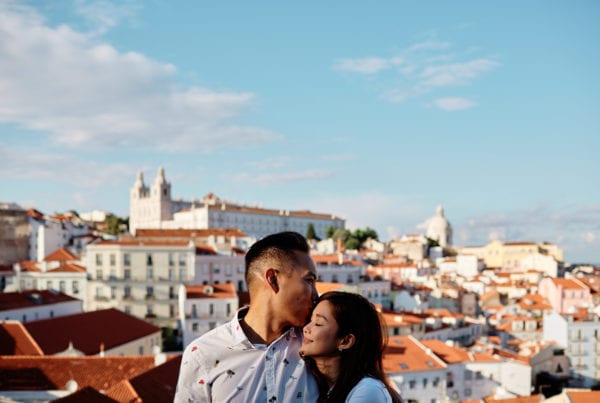 Eliza Sam and Joshua Ngo in a romantic pose with Alfama's roofs as a backdrop, during a photoshoot in Lisbon